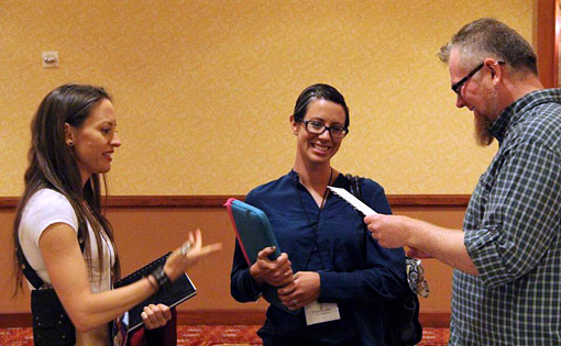 Anna Maltese (left) presents Daniel Loxton with a bizarre coincidence after his talk at The Amazing Meeting 2014, while his wife Cheryl Hebert looks on. (Photograph by David Patton. Used by permission.)